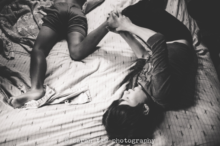 two brothers wrestling in their room during a day in the life family documentary photography session in the asheville NC region