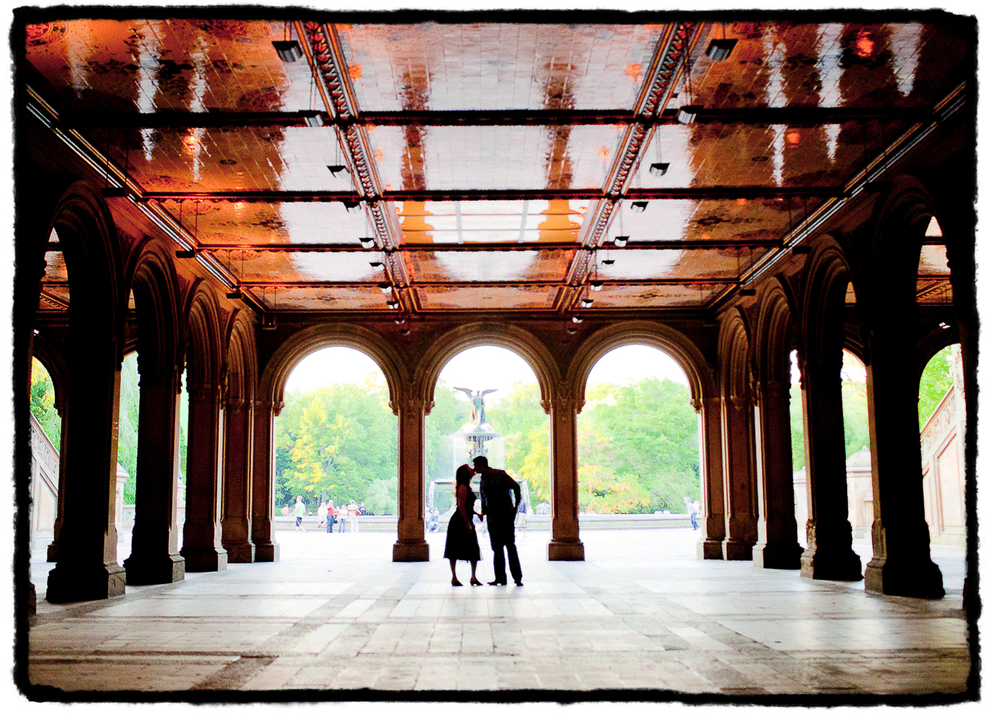 Engagement Portrait: Amy & Jon share a kiss by Bethesda Fountain in New York's Central Park.