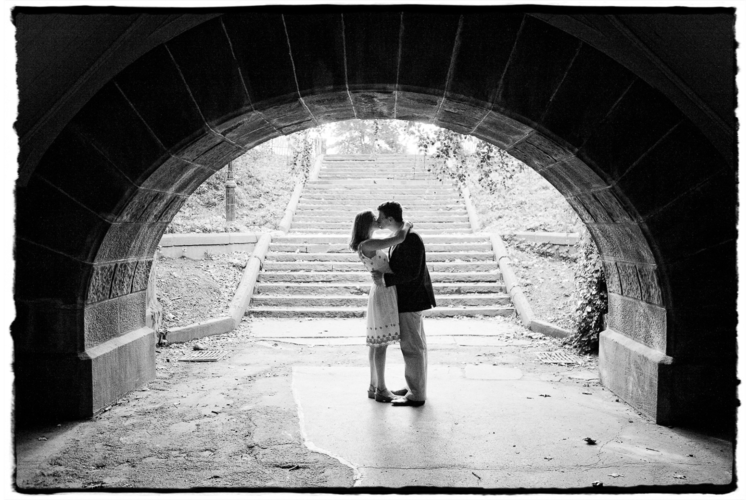 Engagement Portraits: a kiss is framed nicely in a tunnel at Central Park.