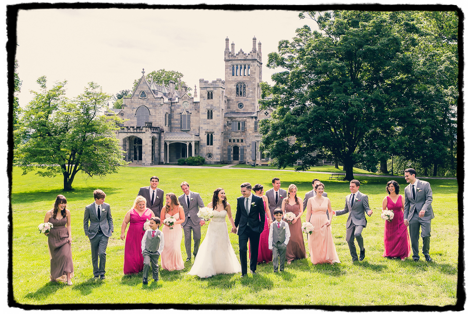A wedding party in shades of pink and grey outside at Lyndhurst Castle in Westchester NY.