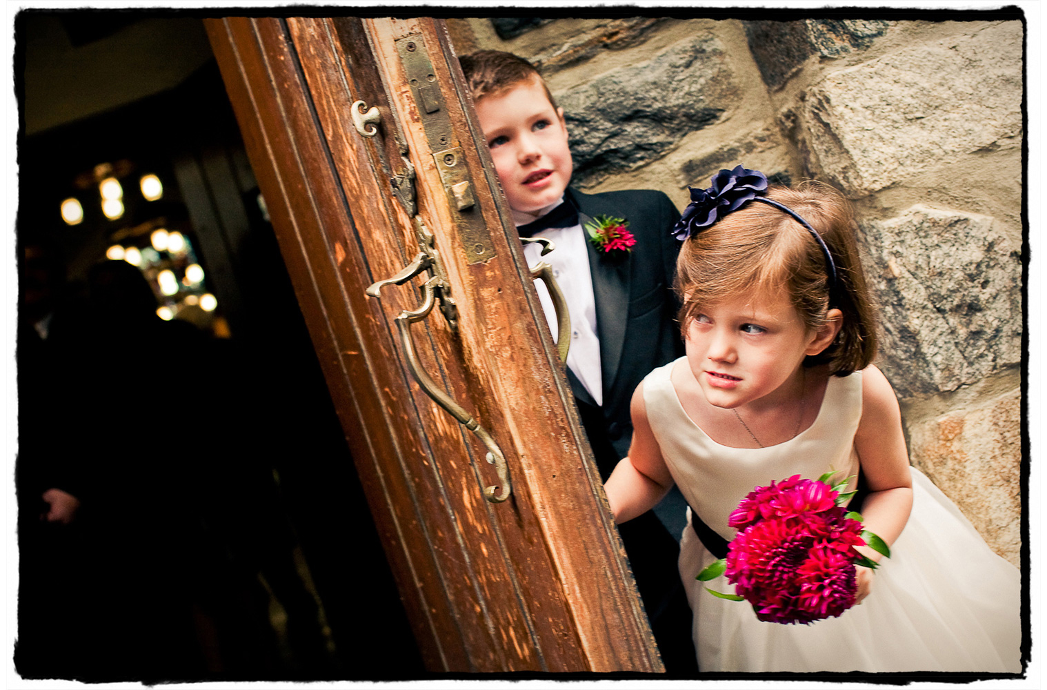 This flowergirl and ring bearer hold the door as adults stream out of the church after a lovely ceremony preceding a reception at The Garrison.