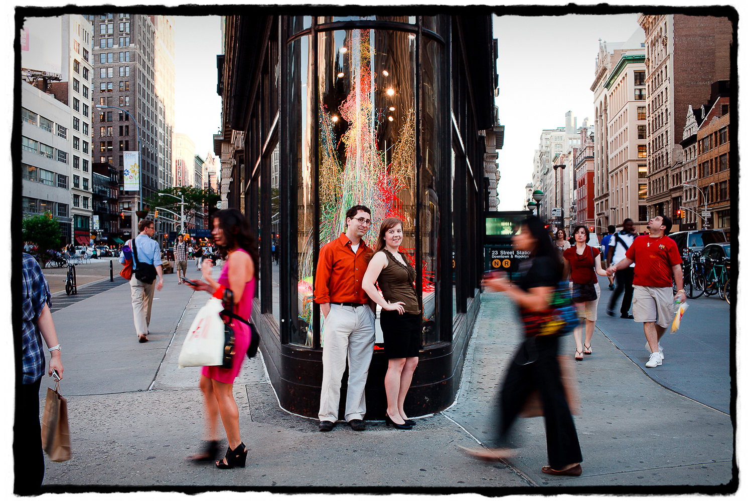 Engagement Portrait: Katie & Jason stop to take in the action in front of NYC's Flatiron Building.